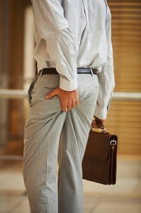 Businessman squeezing his behind